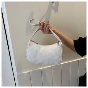 Detailed texture of white corduroy underarm bag held by hand in a minimalist style