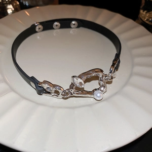 Détail du pendentif argenté avec cristal et perle sur un ras-du-cou noir