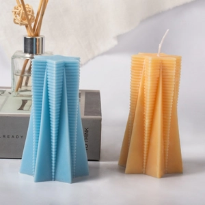 Star shaped ribbed aromatherapy candles in blue and orange on a cozy home setting