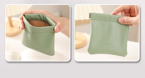 Close-up of light green PU leather makeup pouch with brown lining and squeeze closure
