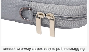 Detail of smooth double metal zippers and D-ring on a grey fabric laptop sleeve