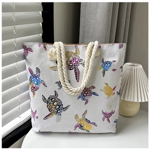 Detail showing colorful turtle print on linen tote bag with rope handles for women