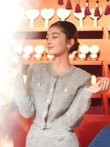 Detail of grey knitted cardigan with rhinestone floral embellishments on the neckline