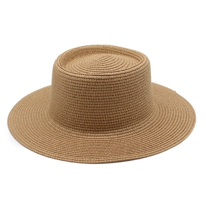 Macro view of tightly woven spiral straw texture on flat top wide brim summer sun hat