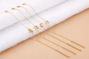 Detail of gold letter bracelets A to D with small rhinestones on adjustable chains