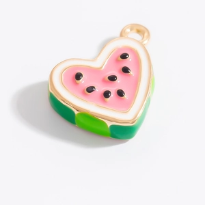 Détail d'un pendentif en forme de cœur pastèque avec émail rose et bordure dorée
