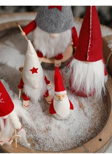 Detail of Christmas gnome shelf sitters with wooden skis on artificial snow background