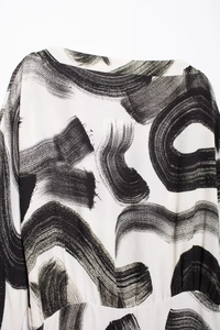 Close-up of white chiffon fabric with abstract black brush stroke pattern for women's dress