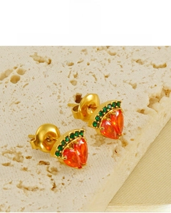 Détail de boucles d'oreilles cœur plaquées or 18K avec pierre orange et cristaux verts