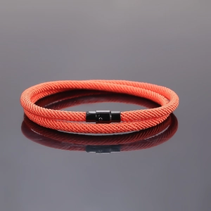 Close-up of double-layer orange braided rope bracelet featuring a black magnetic clasp