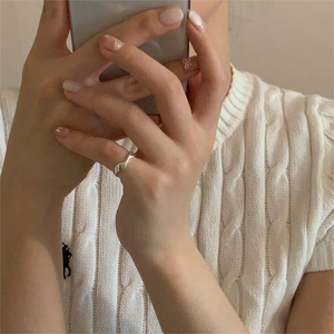 Detail of minimalist wavy S925 sterling silver ring worn for a modern lifestyle look
