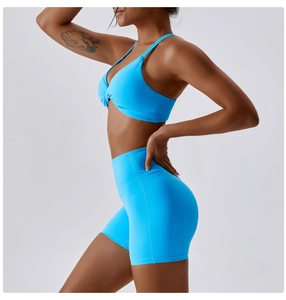 Detail of blue cross-twist sports bra and high-waisted shorts with elastic fabric