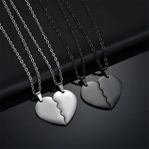 Couples heart pendant necklaces in black and silver finishes on leather background