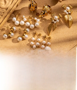 Detail of vintage 18K gold plated bow earrings with freshwater pearls and zircon accents