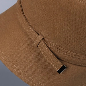 Brown women's bucket hat detail featuring fine woven fabric and black metal aglets