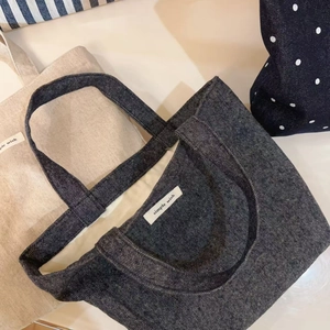 Detail of herringbone and linen tote bags with simple wish labels and woven handles