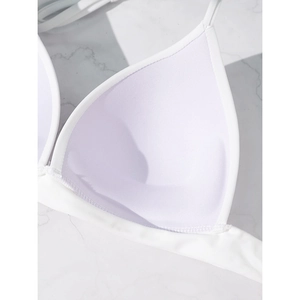 Detail view of white triangle bikini top showing breathable mesh lining and removable padding