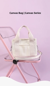 Detail of off-white canvas tote bag featuring an adjustable shoulder strap and front pocket