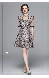 Detail of beaded mandarin buckle and lace floral trim on high waist vintage dress
