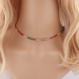 Gros plan d'un collier ras du cou serti de zircons arc-en-ciel sur base dorée