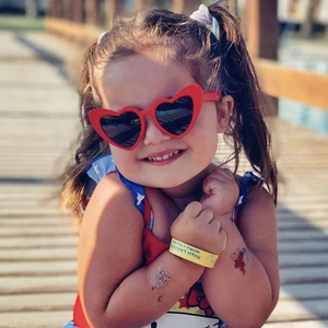 Gros plan de lunettes de soleil rouges en forme de cœur pour enfants portées dehors