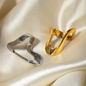 Minimalist irregular stainless steel rings in gold and silver finish on silk background