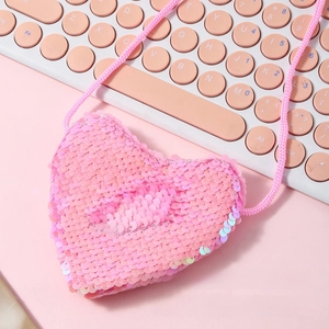 Close-up of heart-shaped mini sequin purse with pink woven strap and shiny finish