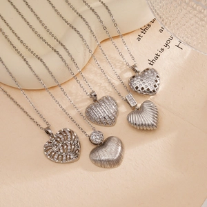 Collection of silver heart pendant necklaces with crystals on a minimalist background