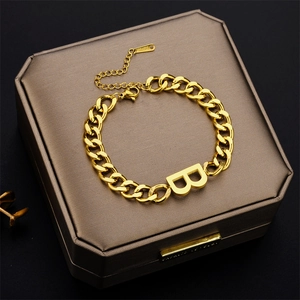Gold-tone stainless steel chain bracelet featuring a large B letter pendant on a gift box