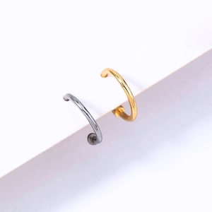 Macro view of minimalist U-shaped nose rings in silver and gold metallic finish