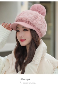 Detailed texture of pink knit warm hat featuring a soft fluffy pom-pom and sun visor brim
