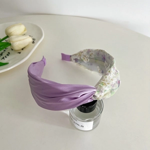 Purple satin headband with floral embroidered sheer mesh mesh detail on a perfume bottle