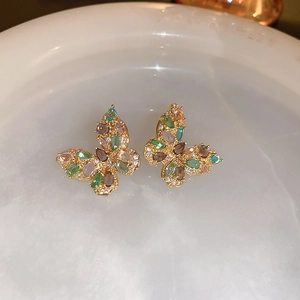 Detailed close-up of butterfly earrings with colorful cubic zirconia in gold setting
