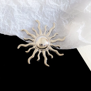 Macro detail of sunburst brooch with silver plating and polished mirror finish