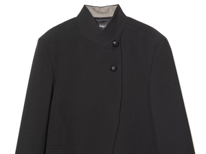 Close-up of black blazer standing collar with unique side-button closure detail