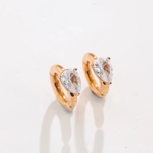 Detailed close-up of water drop zircon earrings in gold titanium steel with pear cut stones