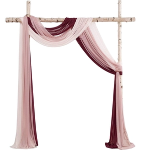 Detail of burgundy pink and peach sheer chiffon drapes on a rustic birch arch