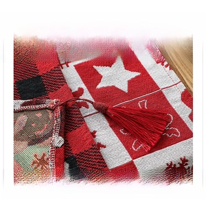 Detail of Christmas table runner featuring red tassels and festive snowflake patterns