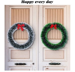 Detail of white and green Christmas wreaths with red bows on white wooden doors