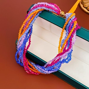 Detail of multi-strand beaded necklace with colorful faceted crystal beads and gold clasp