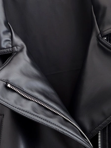 Macro shot of silver metal zipper and premium leather texture on a black jacket