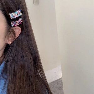 Détail de barrettes rectangulaires avec strass colorés portées par un mannequin