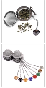 Close-up of stainless steel tea infuser ball with heart-shaped natural stone pendants