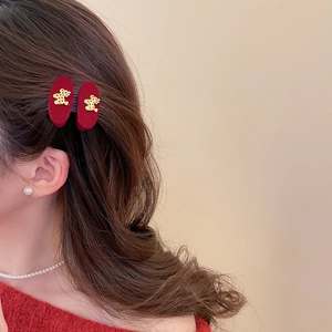 Close-up of model wearing plush red velvet triangle hair clips with golden bear detail