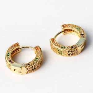 Macro detail of gold-plated hoop earrings featuring multi-color pavé zircon stones