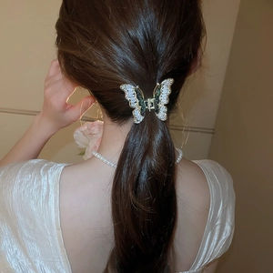 Dettaglio del fermaglio per capelli a farfalla con zirconi indossato da una modella