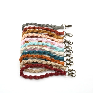 Dettaglio ravvicinato di portachiavi boho fatti a mano in cotone con ganci in metallo bronzo