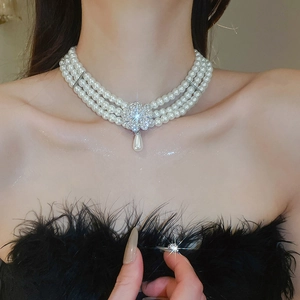 Detail of multi-layer pearl choker with floral rhinestone clasp and teardrop pearl pendant