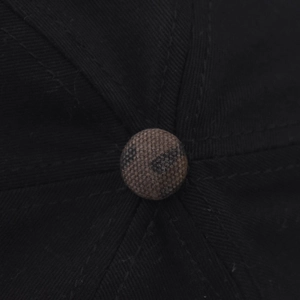 Gros plan sur le bouton supérieur d'une casquette en coton noir avec motif léopard contrasté