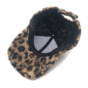 Detail view of leopard print plush baseball cap showing black lining and adjustable strap